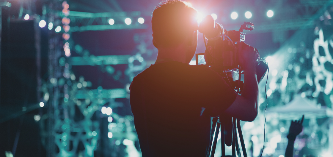 Member of a TV crew holding a camera filming an event